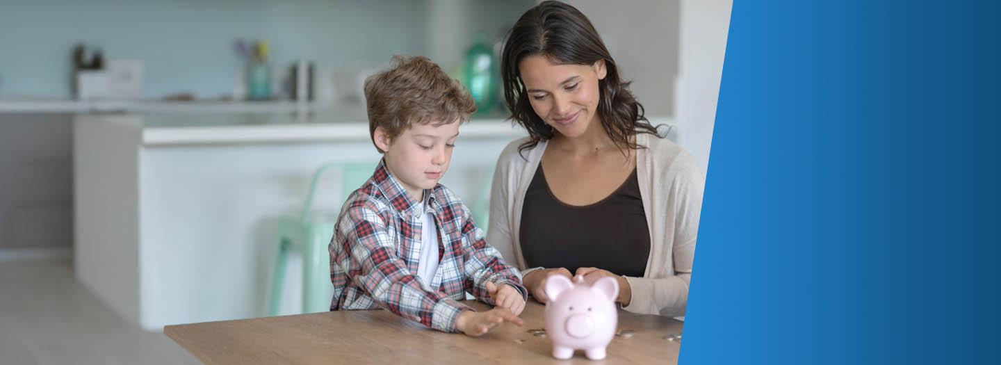 Boy with mom counting coins and putting them in a piggy bank
